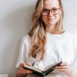 Smart Textiles - Smiling student with agenda between books in house