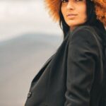 Hat Styles - A woman in a yellow dress and black hat sitting on a bench