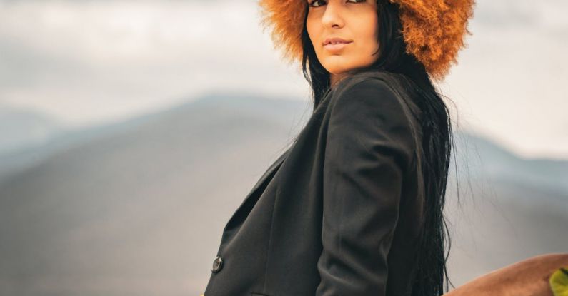 Hat Styles - A woman in a yellow dress and black hat sitting on a bench