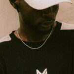 International Streetwear - A man wearing a baseball cap and a black shirt