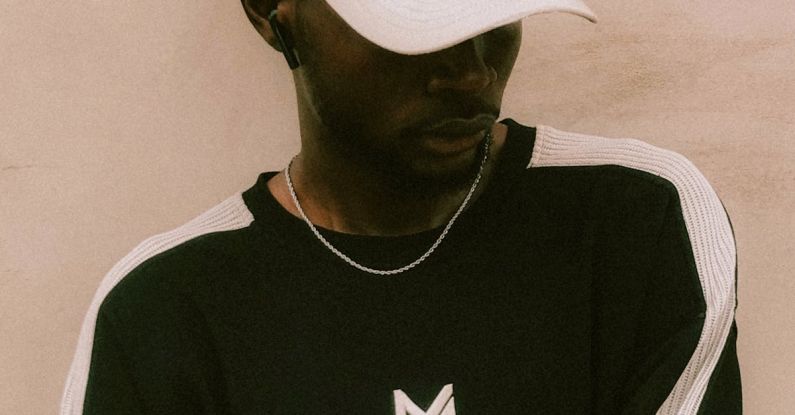 International Streetwear - A man wearing a baseball cap and a black shirt