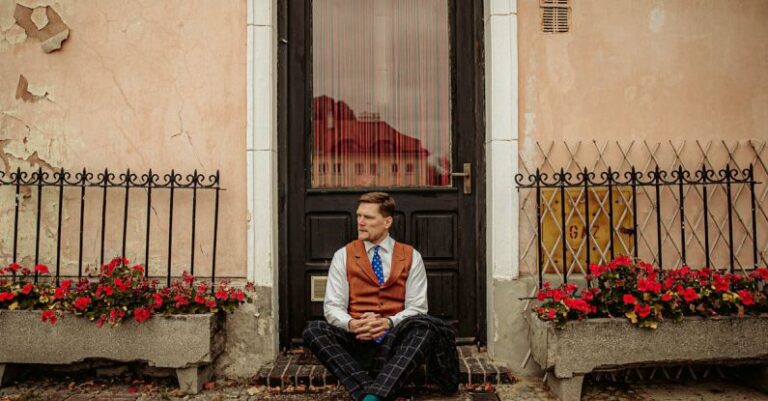 Vintage Styles - A man sitting on a bench in front of a building