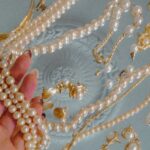 Vintage Accessories - Person Holding a Pearl Necklace on Silver Tray