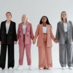 Outfits - Women in Blazer and Pants Standing while Holding Hands