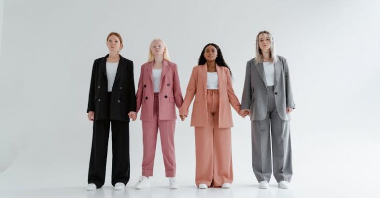 Outfits - Women in Blazer and Pants Standing while Holding Hands